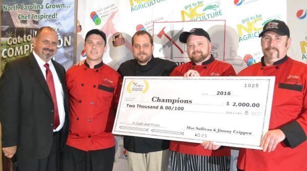 Team Vidalia Boom shows off the $2,000 grand prize and their red chef jackets after taking home first place in the Got to Be NC Competition Dining Series.