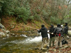 The "Hillbilly Blood" film crew passes gear over a river, season one of "Hillbilly Blood."