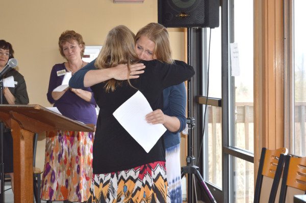 A local woman receives hugs and support after sharing her personal story of life-changing experience at Hospitality House.