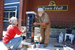 Willie Baucom and Keith Lambert installing a custom AppalCART bus stop marker on West King Street on Thursday, Aug. 2. Photo by Ken Ketchie