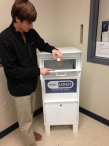 Logan Shaut, a Project Lazarus intern for the Watauga County Sheriff's Office, demonstrates how the medication dropbox is used.