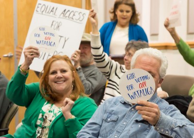 Watauga County Republican Chair Anne-Marie Yates holds up a sign that says “Fair Voting for All Watauga" at a Board of Elections meeting in March.