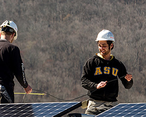 Evan Dubay, right, installs solar panels on a net-zero energy house that will be exhibited at the Solar Decathlon Europe 2014 in Versailles, France. Dubay is a senior appropriate technology major at Appalachian State University. Photo by Marie Freeman