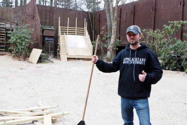 Danny Wilcox works to prepare for the amphitheater stage for the upcoming Daniel Boone Rail Jam.